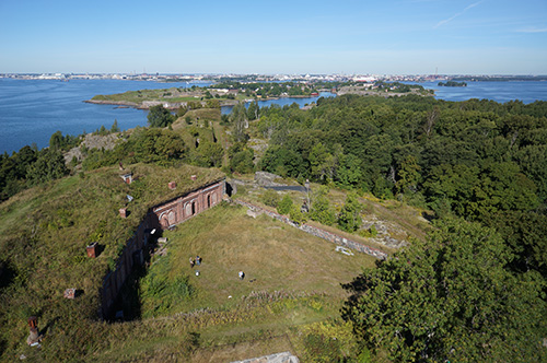 Tiilestä muurattu rakennus vallituksen alla, saaria ja kauempana mantereen rakennuksia.
