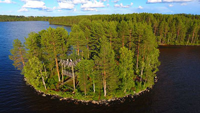 Pieni saari, jossa on näkötorni. Taustalla järvi ja metsää.