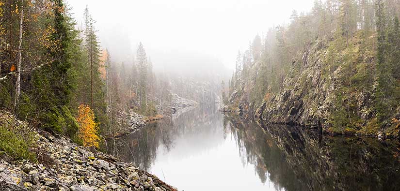 Kapea vesiväylä kulkee korkeiden jäkälää kasvavien kallioiden välissä.