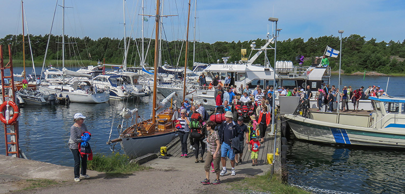 People coming from boats in a small boat harbour in summer.