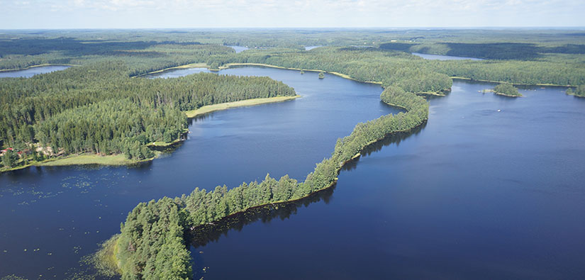Ilmakuva järvi- ja metsamaisemasta. Järvien välissä kulkee pitkä ja kapea metsäinen harju.