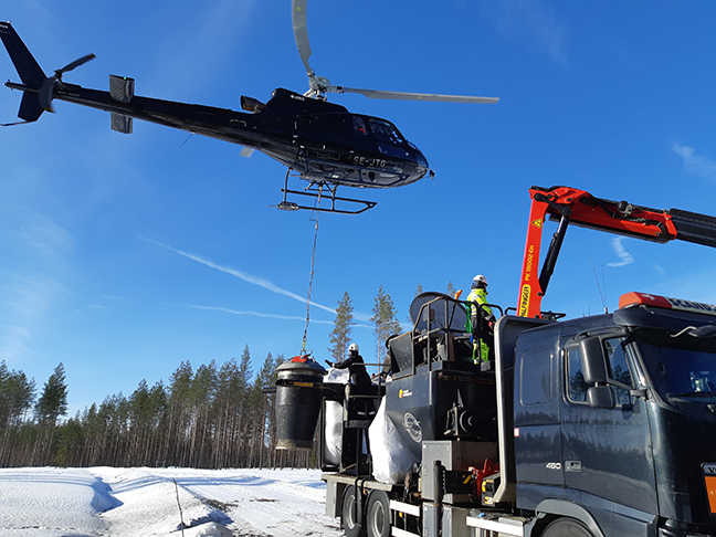 Helikorteri "tankkaa" tuhkalannoitetta seuraavaa lentokierrosta varten. Kuva: Hanna Karppinen