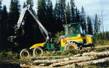 En skördare från 1980-talet arbetar på ett avverkat område.