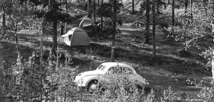 Två tält som sattes upp mitt i skogen, Kuplavolkkari parkerade i skogen i förgrunden.