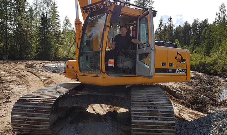 Forestry contractor on a road construction site. The excavator 's door is open. Sunny summer day.