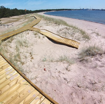 Hiekkarannalla laudasta tehtyjä kulkureittejä.