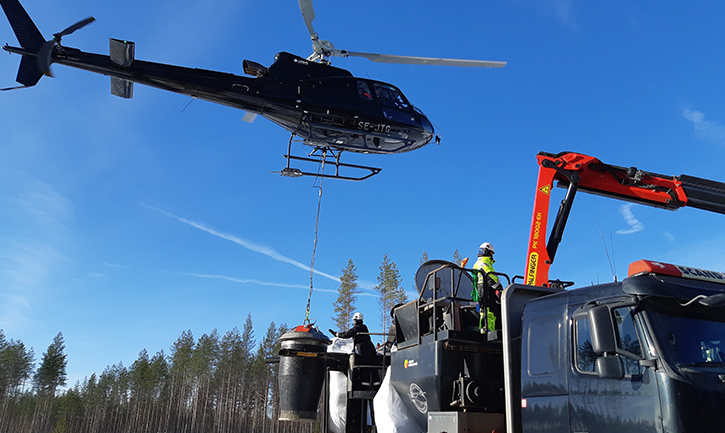 Helikopteri noutaa uuden erän tuhkalannoitetta varastopaikalla