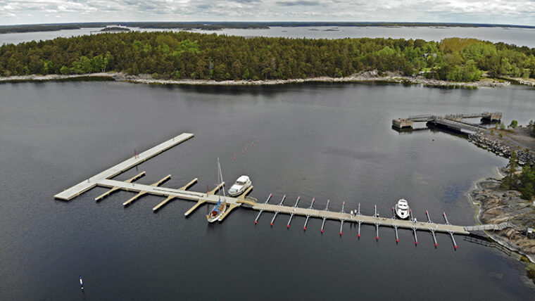 Aerial view of a long jetty. Several woody islands further away.