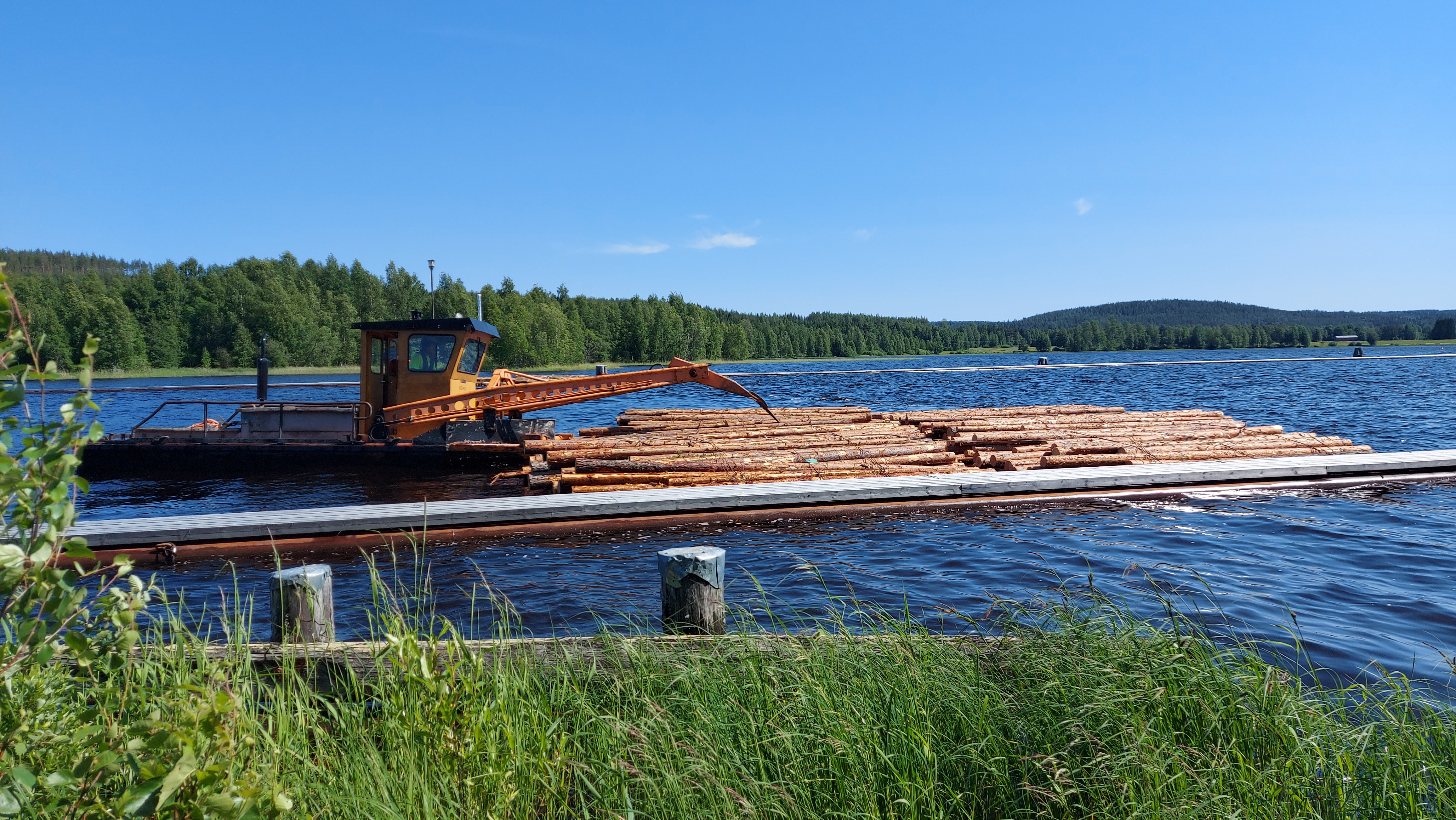 A tugboat moves bound bundles on the lake.