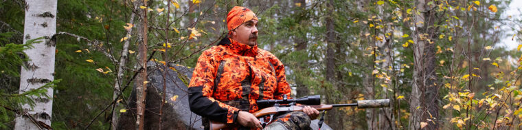 Mies istuu mets&auml;ss&auml; kivell&auml; kiv&auml;&auml;ri k&auml;dess&auml;&auml;n.