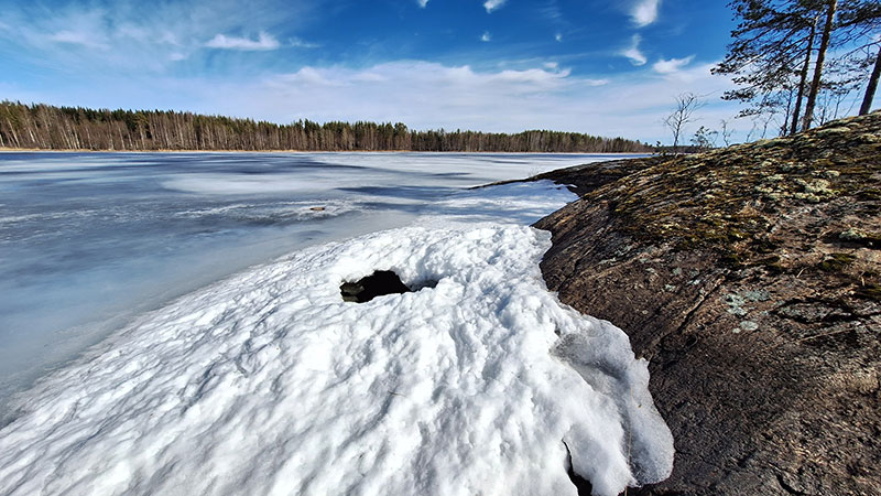 Järven rannassa jään päällä on apukinos.