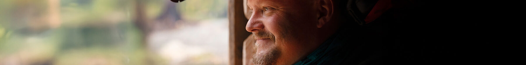 The maintenance man looks out, smiling.