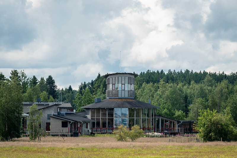 Suuri luontokeskusrakennus kesällä metsän reunassa.