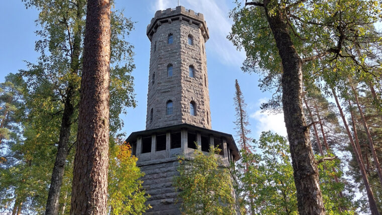 Kivinen torni havupuiden keskell&auml;.