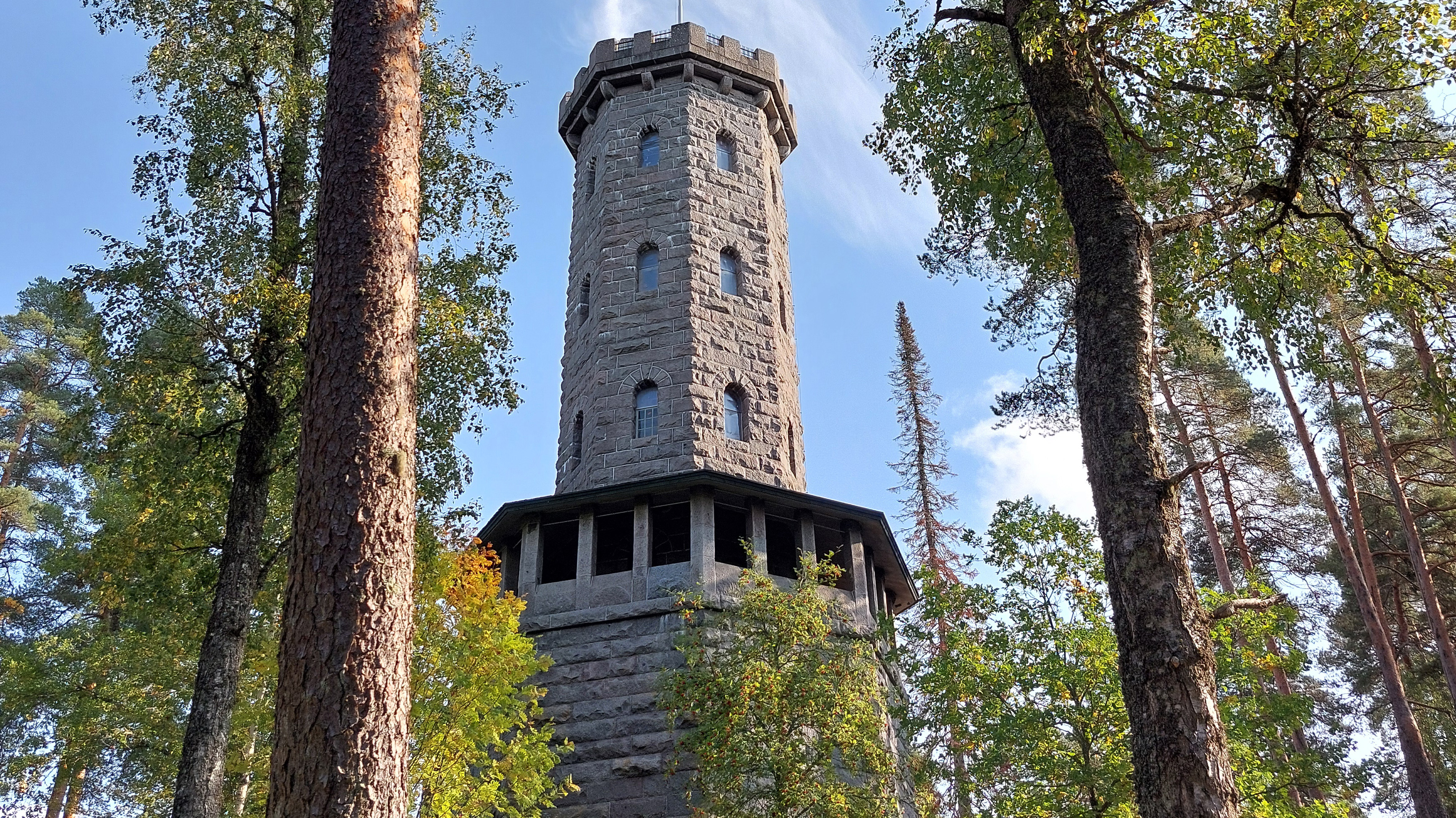 Kivinen torni havupuiden keskellä.