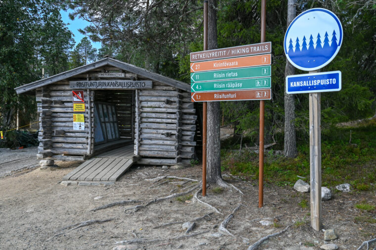 Parkkapaikan reunassa on opastusrakennelma, viittoja ja kansallispuiston merkki.