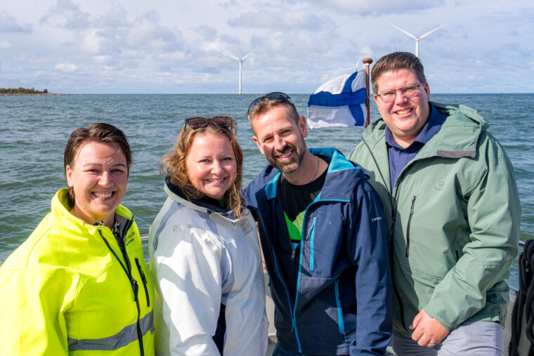 Nelj&auml; iloista ihmist&auml; meren rannalla