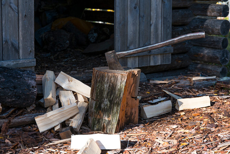 Puuvajan edess&auml; on polttopuita ja kirves.