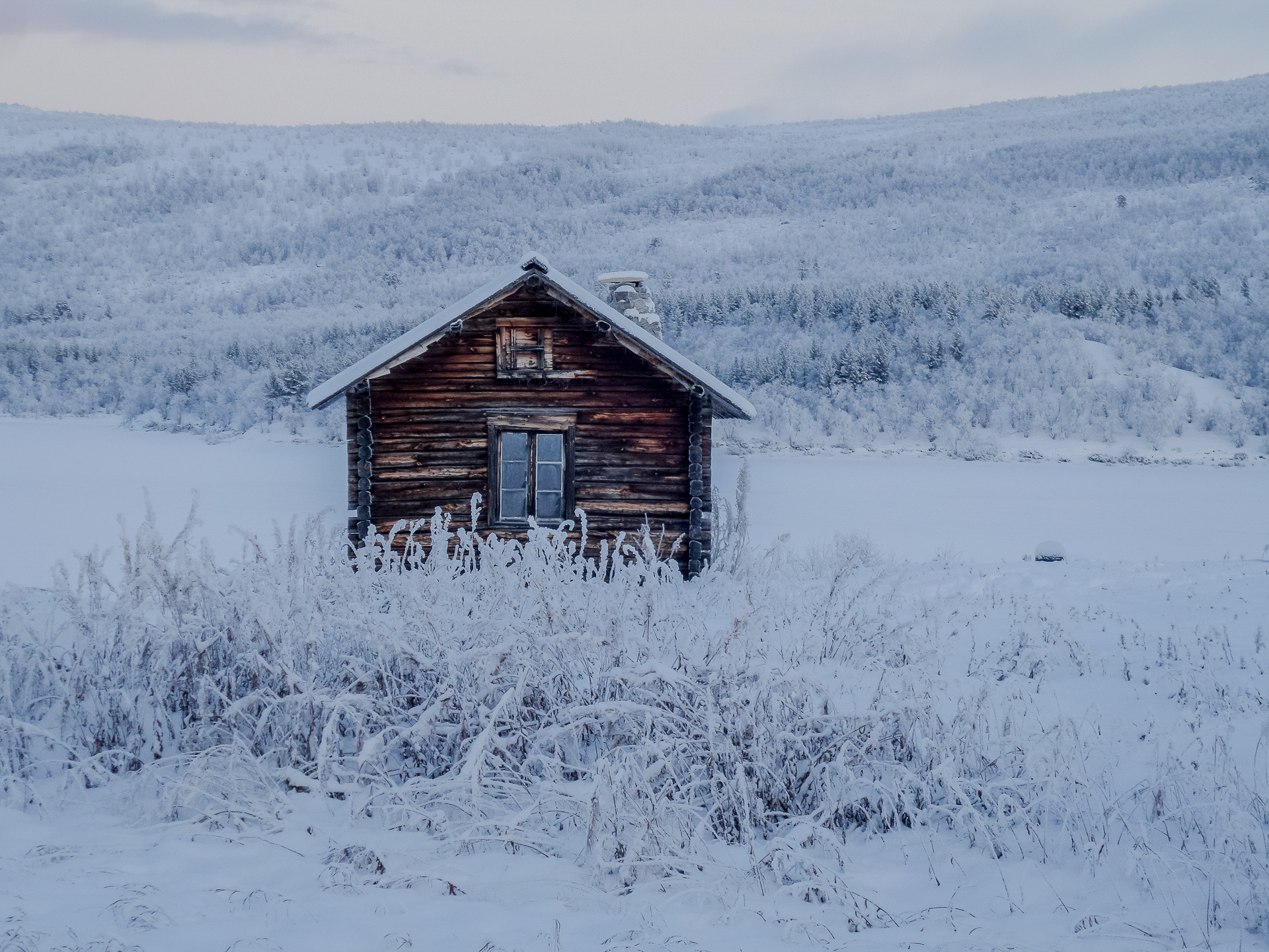 Tupa lumisessa tunturimaisemassa.