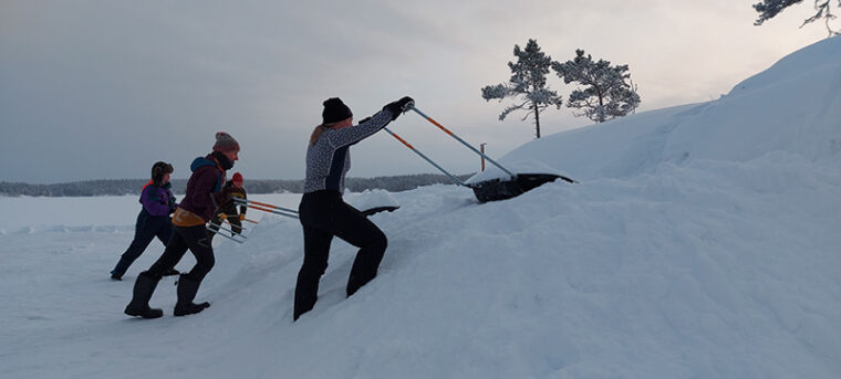 Ihmiset kolaavat lunta j&auml;&auml;ll&auml; kinoksiksi.