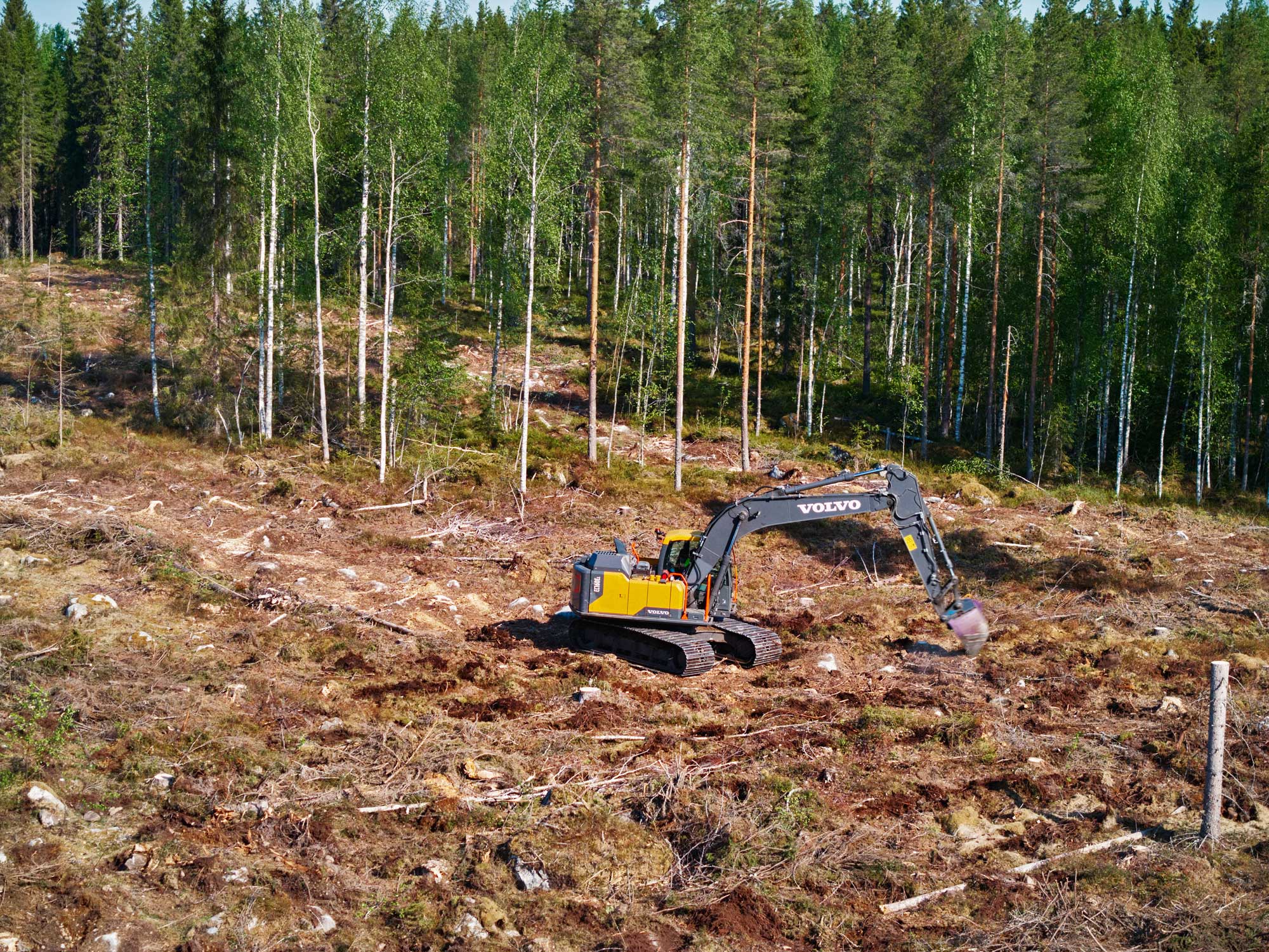 Kaivinkone muokkaamassa istutusalaa.