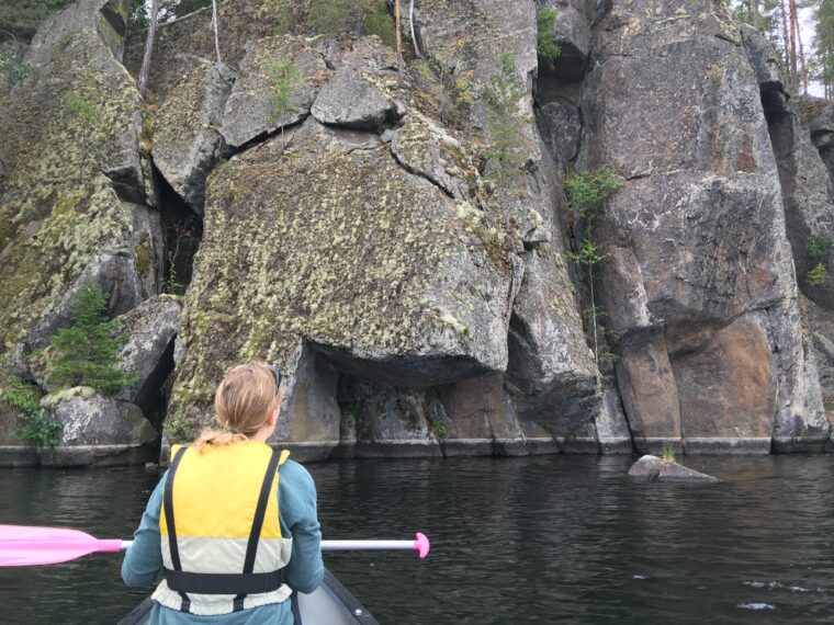 Retkeilij&auml; melomassa ja katsomassa kalliosein&auml;m&auml;&auml;.