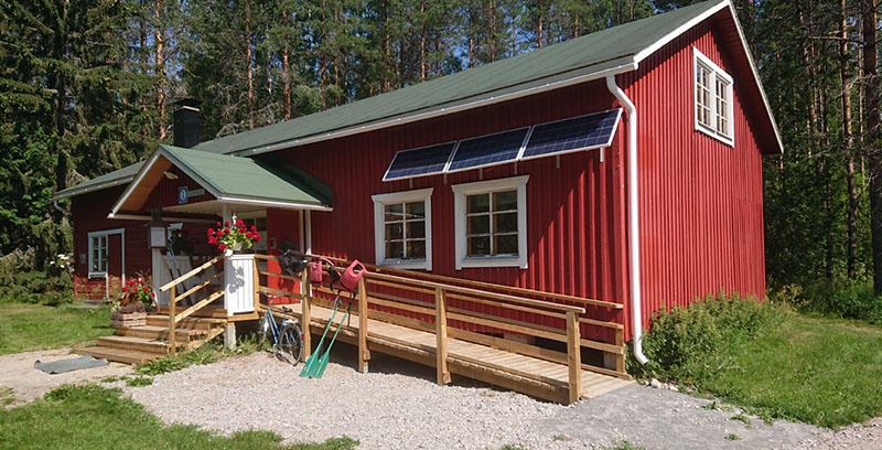 Punamullalla maalattu puolitoistakerroksinen puurakennus. Ovelle johtavat sekä portaat että pyörätuoliliuska. Rakennuksen edusta on nurmikkoa ja sen takana on metsää.