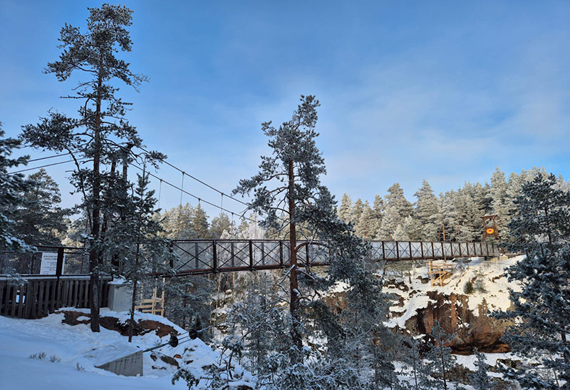 Pitkä riippusilta talvisessa maisemassa.