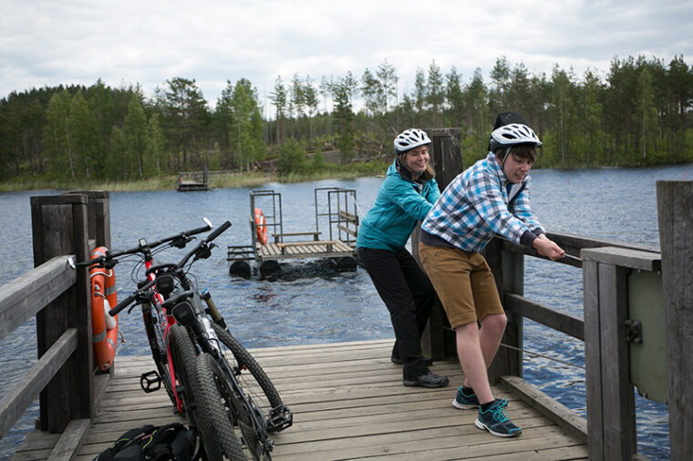 Kaksi py&ouml;r&auml;ilij&auml;&auml; on laiturilla ja kiskoo vetolossia l&auml;hemm&auml;ksi laituria.