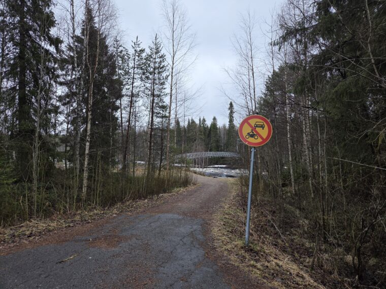 Sillalle johtava polku. Polulla on moottoriajoneuvolla ajo kielletty -liikennemerkki