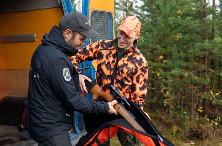 Erätarkastaja tarkastaa metsästäjän asetta.